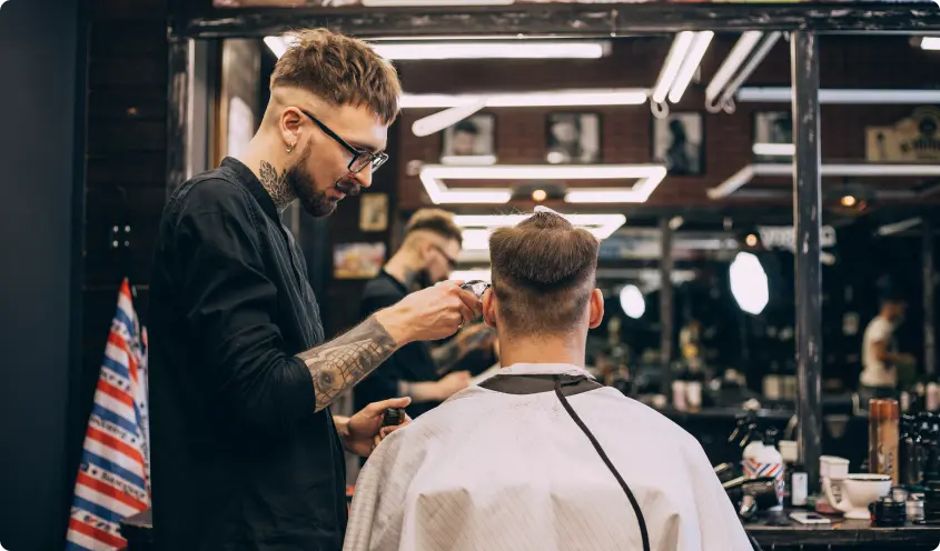 Barber giving a client a haircut in a barbershop